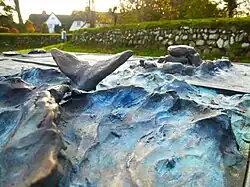 "Table at the Cliff", Bronze reliefs "Whale in a moving sea" and "Hill grave" by Ingo Kühl 2019