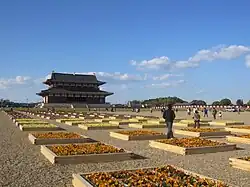 Birds eye view of a palace with several large structures surrounded by a rectangular corridor.