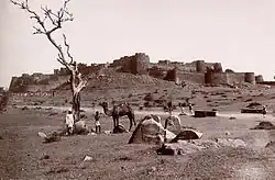 A black and white photograph showing a large fortress on a hill