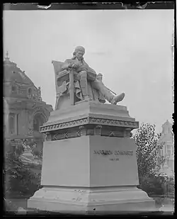Plaster statue of a man sitting in a chair