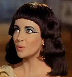 A woman wearing heavy blue eyeshadow and black winged eyeliner