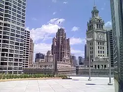 Image of clock tower and another building tower from the terrace of a tall building