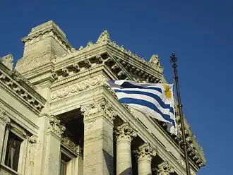Uruguayan flag waving in front of the palace