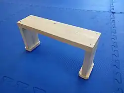 A simple modern meditation stool, used to assist in sitting with the back upright and the legs crossed