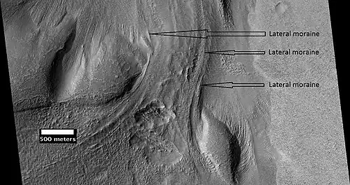 Material Flowing through a crater rim, as seen by HiRISE, under the HiWish program. Lateral moraines are labeled.