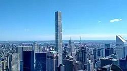 432 Park Avenue and surrounding buildings as seen from 30 Rockefeller Plaza on a sunny day.
