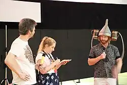 Ryland Tews wearing a drinking hat at the 50th Summer Film School in Uherské Hradiště and standing next to two people