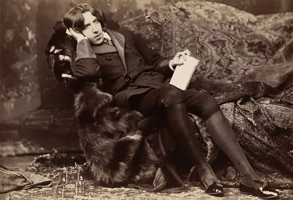 Image 12Oscar Wilde reclining with Poems, by Napoleon Sarony, in New York in 1882. Wilde often liked to appear idle, though in fact he worked hard; by the late 1880s he was a father, an editor, and a writer.