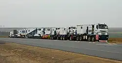 TII Nicolas Tractomas ballast tractors pulling a hydraulic modular trailer with girder bridge.