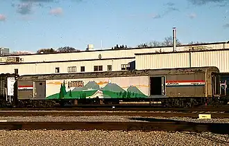 A railway baggage car painted with a mural of mountains