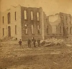 A destroyed brick college in Grinnell with debris surrounding the area