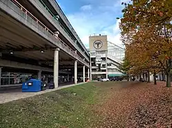 A depressed grassy area and trees next to a large parking garage