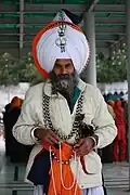 An Akali Singh wearing many Aad Chands in Amritsar and holding prayer beads