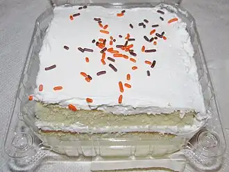 White layer cake with white frosting and colored sprinkles