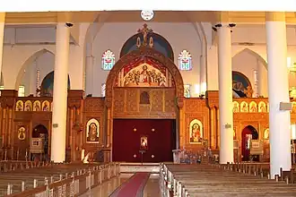 Interior view of modern church showing white columns, wooden elements, and golden religious icons
