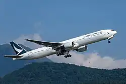 Aircraft takeoff. Side view of aircraft ascending, with landing gear doors open.