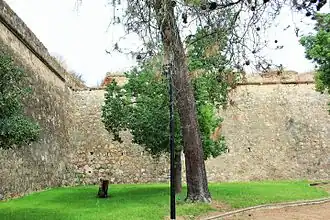Inward-angled curtain wall with arrowslits and embrasures