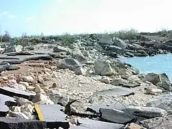 A crumbled roadway at the water's edge