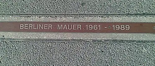 A "BERLINER MAUER 1961–1989" plaque near Checkpoint Charlie signifying where the Wall stood