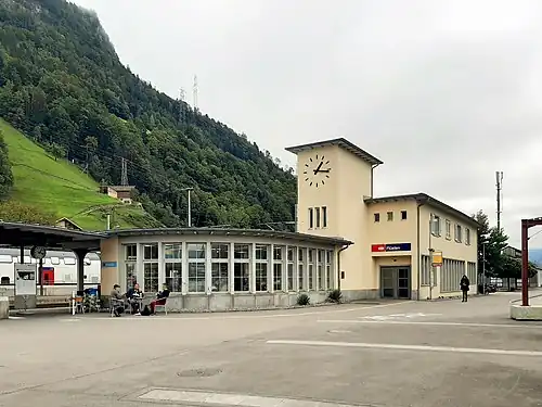 Two-story building with flat roof and adjoining clock tower