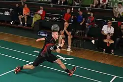 A para-badminton player trying to hit the shuttlecock