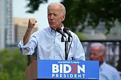 Photo of Biden raising his fist while standing behind a lectern