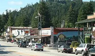 Looking north from Highway 9 at the Boulder Creek Hardware building and the 70-foot-long (21 m) painted mural by John Ton, depicting two phases of the community's history