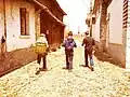 Three boys walk through the streets of Xizhou.