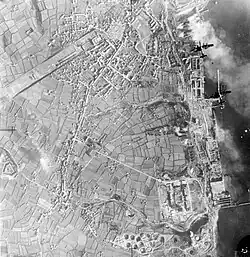 Photograph taken from high level looking down shows two bomber aircraft over port