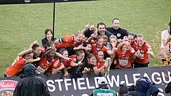 Members of the Brisbane Roar women's team lifting the W-League championship trophy