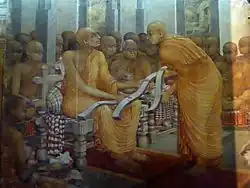 monk giving texts to a more senior monk