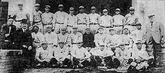 Black and white newspaper clipping depicting baseball players in uniform and several men in suits