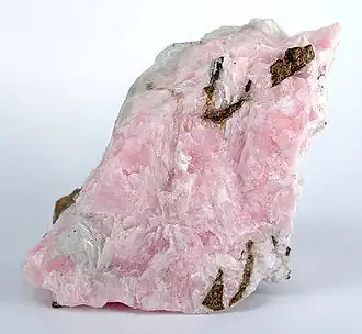 A cristalline rock specimen with a pinkish hue