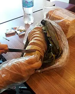 Chả lụa being cut with a knife