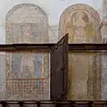 Frescos on the choir walls, partly covered by wooden panels.