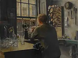 A painting of a man sat at a workbench near a window.
