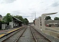 A bus platform and canopy under construction next to a railway line