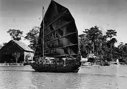 A boat with a dark sail