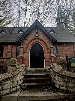 Close up of short flight of steps flanked by stone curved dwarf walls leading to entrance arched doorway