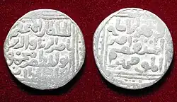 A color photograph of the front and back of a silver coin, which has Perso-Arabic writing on it