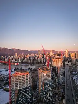 Three tall towers rising beside a waterfront.