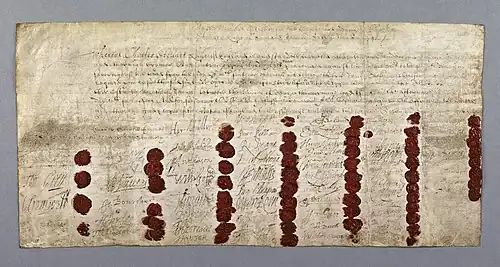 Large hand-written document, coloured yellow with age. There is a block of text at the top, and 59 signatures and red wax seals at the bottom.