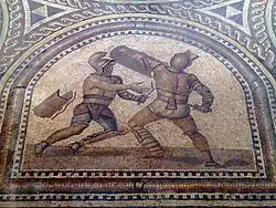 Detail of Gladiator mosaic showing a Thraex and a Murmillo gladiator fighting, each wearing distinct armor and Subligaculum loincloth.