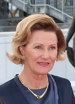 Crown Princess Sonja outdoors, dressed in dark blue, with a gold neckless.