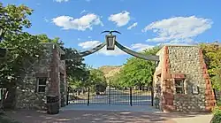 An image of a gate, with cobblestone pillars and an eagle statue on top.