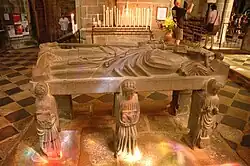 The flagstone depicting Saint Ronan viewed from the other side. The second reclining angel by Ronan's head is touching the top of the cross.