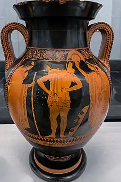 a warrior, unbearded, pulls on body armour: an old man stands to the viewer's left, a finely dressed woman to the viewer's right.