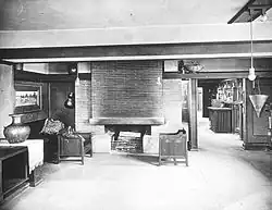 Interior of the drafting room in the studio, which has some furniture and a balcony above