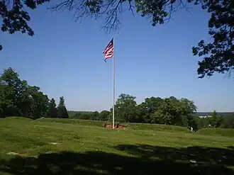 All that remains of Fort Lincoln is the flag, earthenworks, and three cannons at Fort Lincoln Cemetery, Colmar Manor, Maryland. The Old Spring House is off to the left.