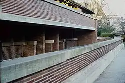 Red brick bollards and piers under the Robie House's southern balcony. Above the bricks are stone slabs. The underside of the balcony is covered in stone.